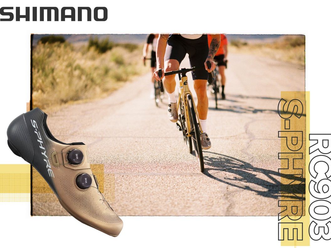 A gold and black Shimano RC903 shoe is shown in side-profile over an image of four road cyclists riding in a hilly region toward the camera.